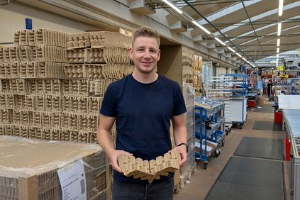 Nicola Huser steht vor Kartonverpackungen