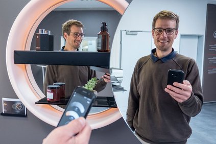 Martin Rüegg steht vor dem Spiegelschrank Schneider LUNE D2W und bedient die Licht App