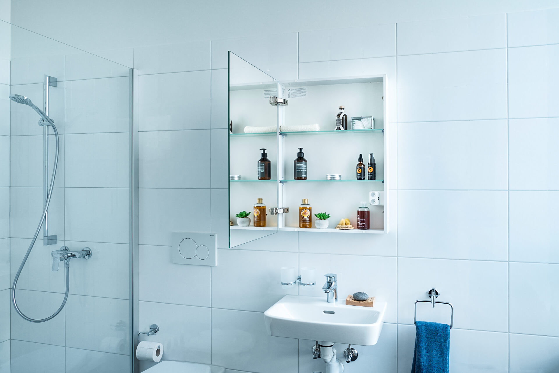 EASY Line Comfort Spiegelschrank an Keramikplattenwand. Lavabo unten. Dusche.