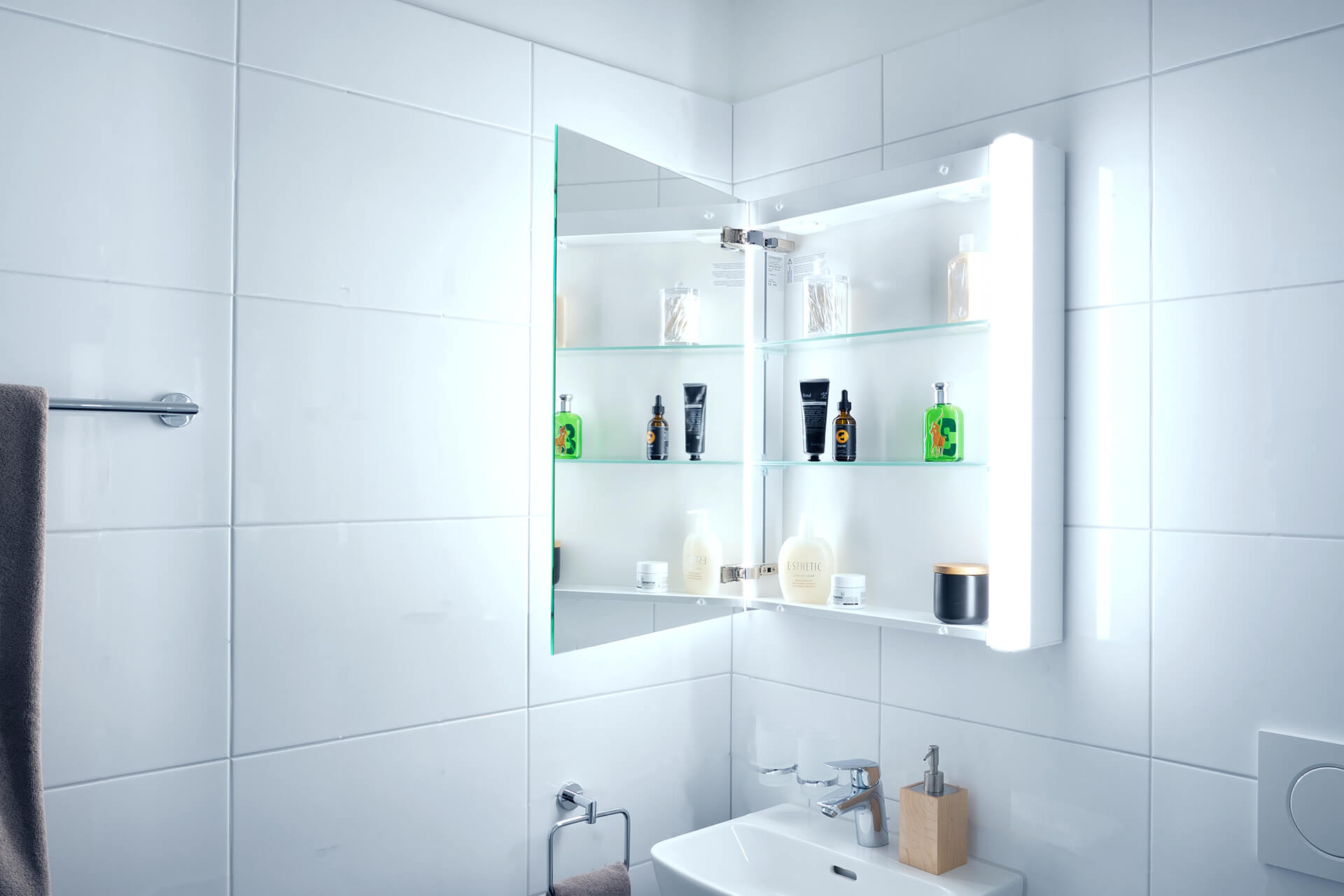 EASY Line Superior LED mirror cabinet - The cubic mirror cabinet. EASY Line Superior LED mirror cabinet mounted on wall. Lighting on each side. With washbasin.