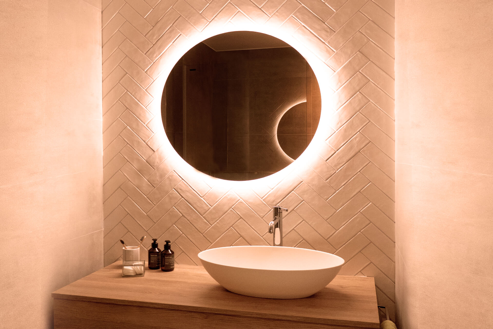 Round mirror with backlight and washbasin.