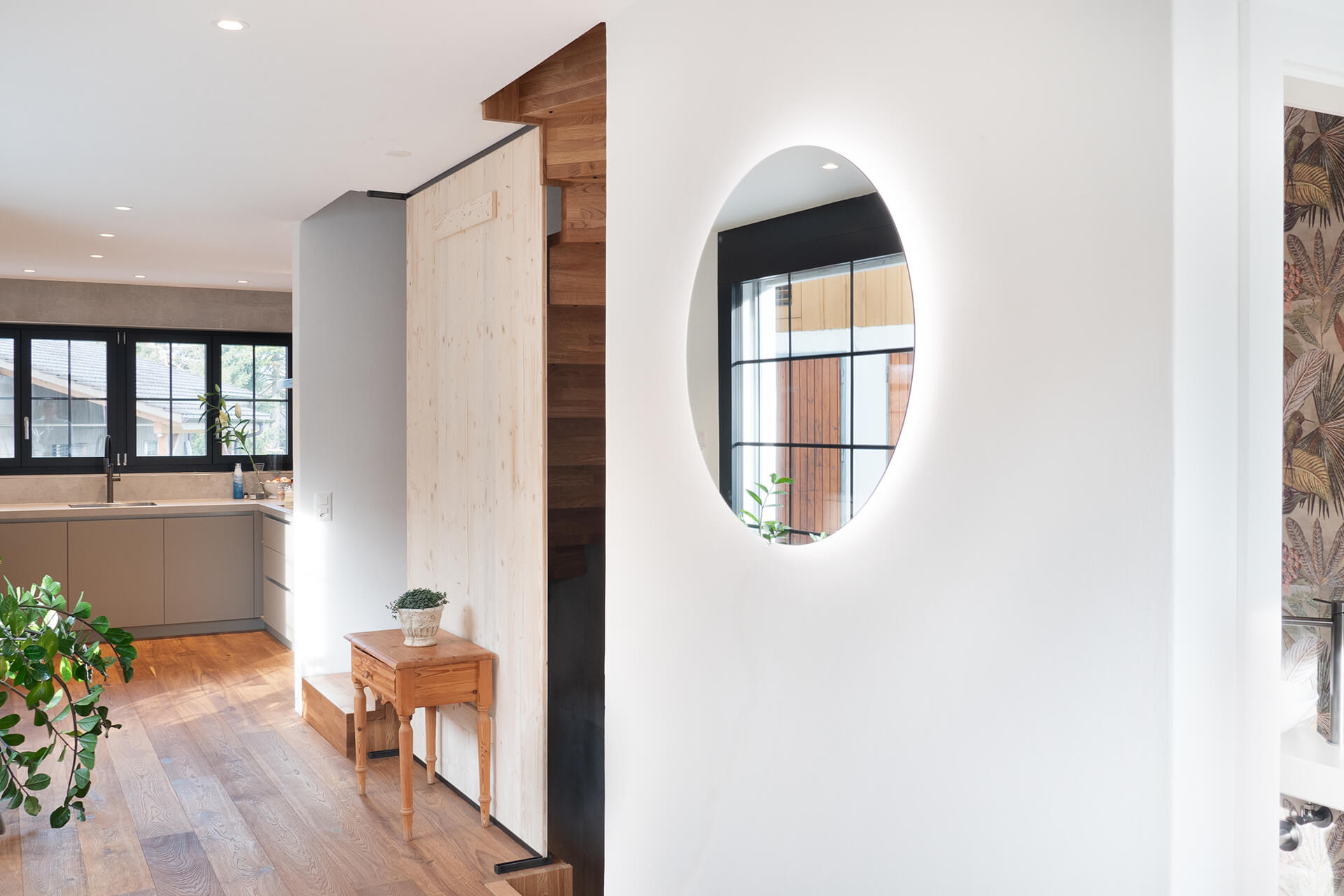 Round mirror with backlight on wall.