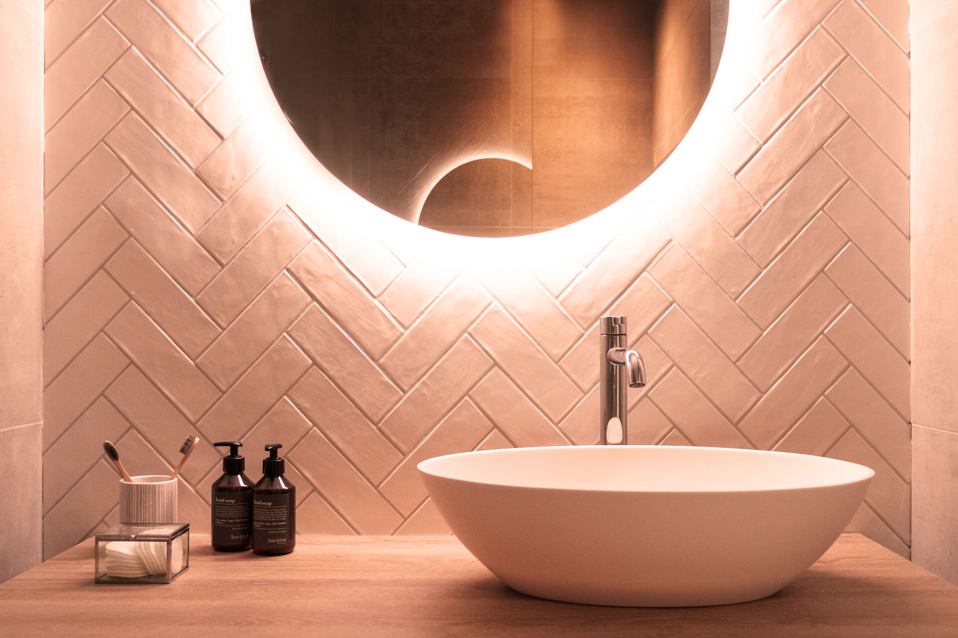 Runder Spiegel mit Hintergrundbeleuchtung an Wand mit Kacheln Detailansicht.