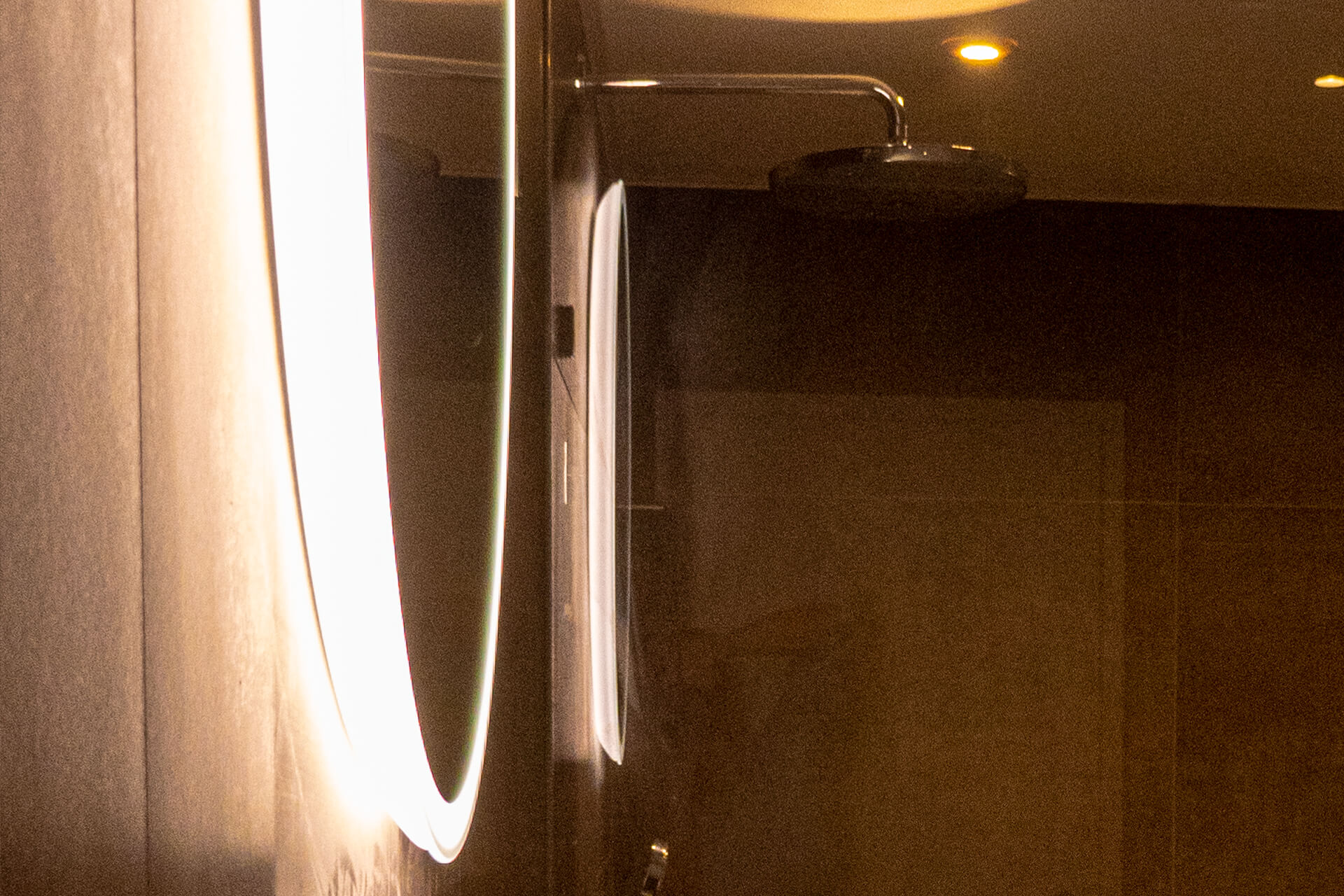 Round mirror with backlight detail below frame.